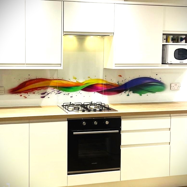 White modern kitchen with custom printed glass splashback featuring a colourful wave design behind the hob